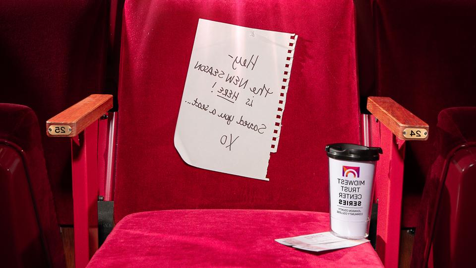 亚德利大厅的一把天鹅绒剧院椅，上面写着:嘿，新一季来了! 给你留了个座位... xo